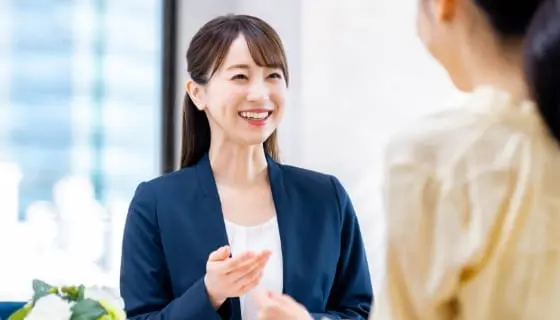 ジェスチャーを交えて笑顔で会話する女性の様子