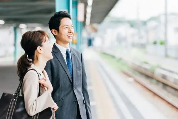 同行するスタッフと一緒に駅のホームで電車を待つ様子